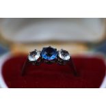 A blue and colourless paste graduated three stone ring, stamped '9ct & sil', size Q.