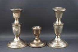 A pair of Continental short round candlesticks with gadrooned borders, marked 'Sterling Weighted',