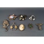 Eight various silver and white metal brooches in various designs including an oval shell cameo of a