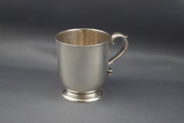A Victorian silver christening mug with a leaf-capped double-scroll handle & on a stepped foot,