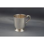 A Victorian silver christening mug with a leaf-capped double-scroll handle & on a stepped foot,