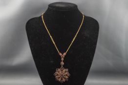 An early 20th century gold and garnet pendent necklace,