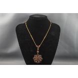 An early 20th century gold and garnet pendent necklace,