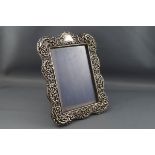 A late Victorian silver mounted photograph frame embossed with scrolls, leaves,