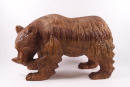 A carved figure of a bear with a fish in his mouth,