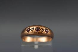 An Edwardian 9ct rose gold and small ruby and diamond gypsy ring, Birmingham 1905, size O+, 1.