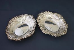 A pair of modern silver shaped oval sweet dishes, each embossed with flowers,