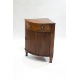 A 19th century mahogany bow fronted corner cabinet with sliding drawer above a tambour front,