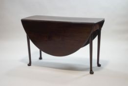 A mahogany drop leaf table with turned tapering legs and pad feet,