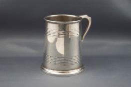 A silver straight-sided christening mug with two engraved bands, uninscribed,