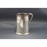 A silver straight-sided christening mug with two engraved bands, uninscribed,