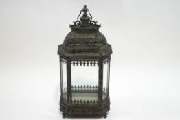A large simulated bronze lantern with swing handle on four scroll feet,