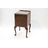 A mahogany bedside cabinet on cabriole legs with one cupboard door,