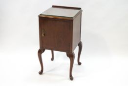 A mahogany bedside cabinet on cabriole legs with one cupboard door,