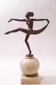 An Art Deco spelter figure of a dancing girl with arms outstretched,