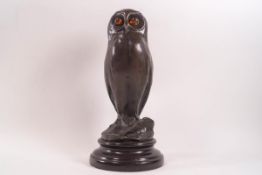 After Milo, a bronze figure of an owl with amber eyes,