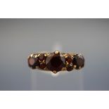 A hallmarked 9ct gold half hoop ring set with garnets. Hallmark has worn. Gross weight; 2.