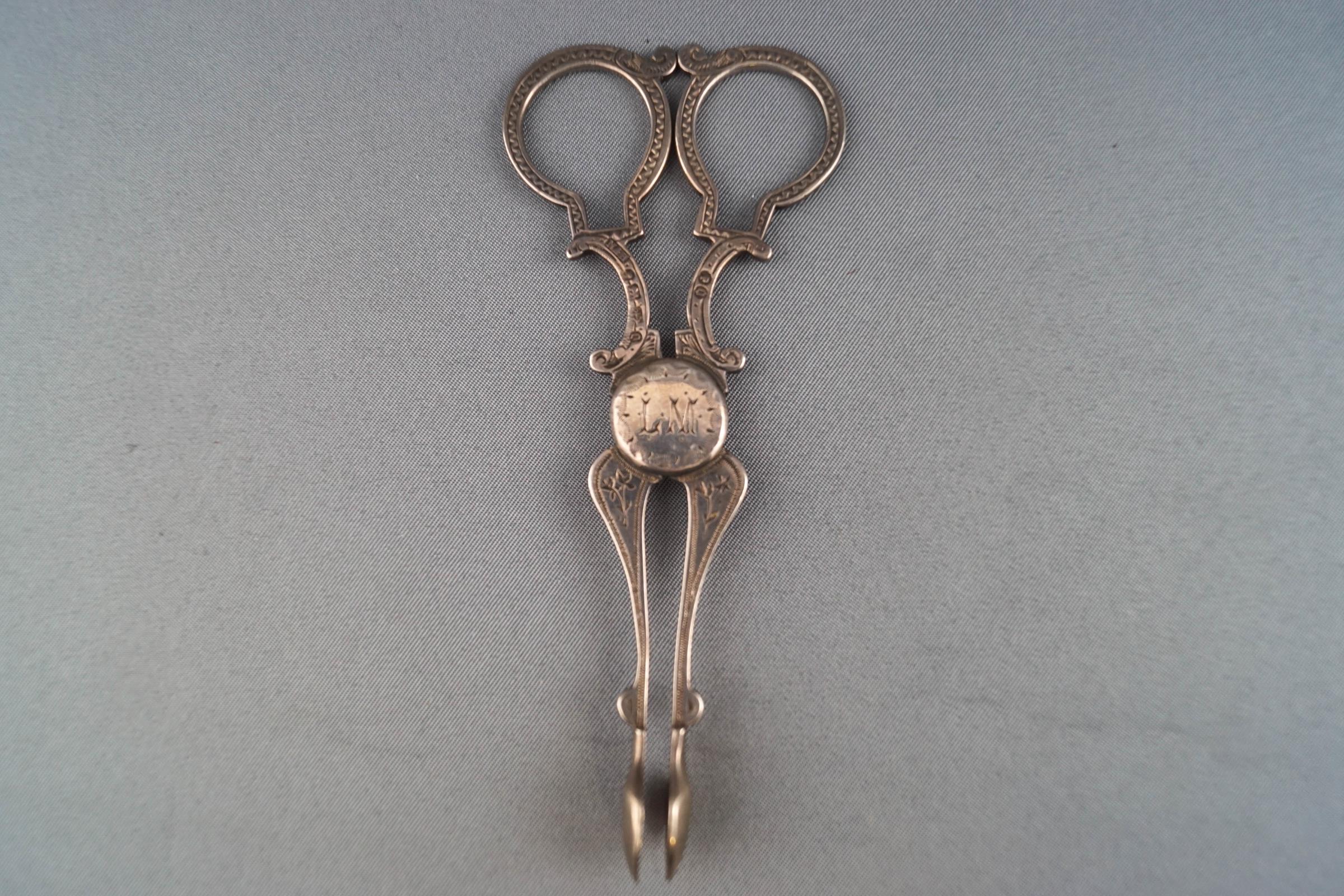 A pair of Victorian silver sugar nips, with bright cut decoration engraved "LM",