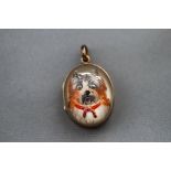 A yellow metal locket having a domed glass front and depicting a dog intaglio,