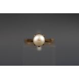 A hallmarked 9 carat gold single pearl ring. Gross weight: 2.