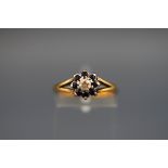 An 18 carat gold cluster ring set with 8 sapphires and a central diamond.