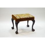 A rectangular stool with tapestry and velvet seat on carved cabriole legs with ball and claw feet
