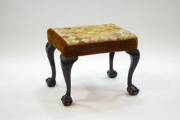 A rectangular stool with tapestry and velvet seat on carved cabriole legs with ball and claw feet