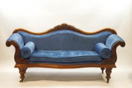 A Victorian mahogany show frame sofa with arched back, scroll arms and turned legs,
