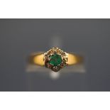 An 18 carat emerald and diamond seven stone cluster ring. Hallmarked 18ct, Birmingham. 2.