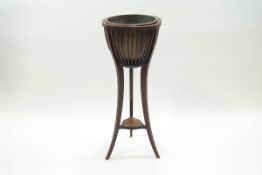 A Regency style mahogany jardiniere stand with brass liner, slatted surround and sable legs,