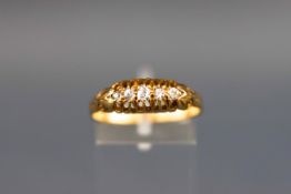 An Edwardian yellow metal half hoop ring set with five graduated old brilliant cut diamonds