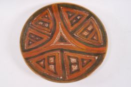 A Poole pottery Studio plate with orange glaze triangular design on a green ground, 20.