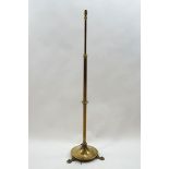 A brass telescopic standard lamp on round base, issuing to three Art Nouveau style feet,