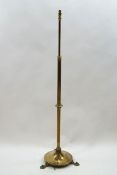 A brass telescopic standard lamp on round base, issuing to three Art Nouveau style feet,