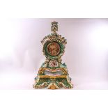 A large porcelain Salon clock with green and profuse floral decoration all around, 8 day movement,