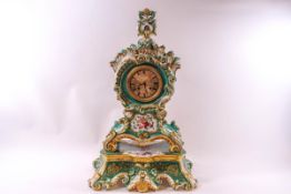 A large porcelain Salon clock with green and profuse floral decoration all around, 8 day movement,
