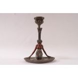 An Art Nouveau painted metal candlestick modelled as a kneeling lady on a lily pad,