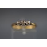 A stamped 18ct/plat three stone ring set with three old brilliant cut diamonds measuring from 2.