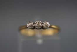 A stamped 18ct/plat three stone ring set with three old brilliant cut diamonds measuring from 2.