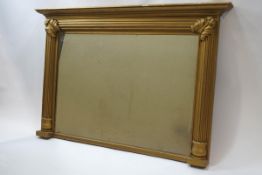 An over-mantel mirror, within gold painted frame, moulded reeded column and acanthus leaf corners,