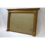 An over-mantel mirror, within gold painted frame, moulded reeded column and acanthus leaf corners,