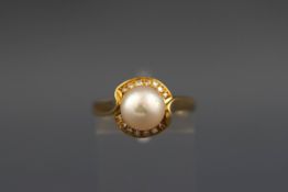 A yellow metal cluster ring set with a cultured pearl measuring 8.2mm.