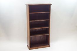 A mahogany standing bookcase with four fixed shelves on a plinth base, 125cm high x 66cm wide x 25.