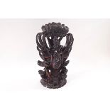 An Indonesian carved hardwood statue of a figure astride a god,