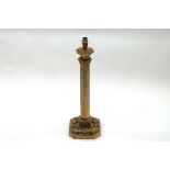 A brass octagonal column table lamp with ecclesiastical detail,