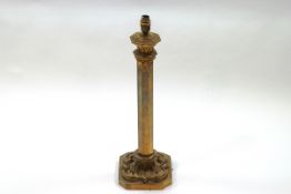 A brass octagonal column table lamp with ecclesiastical detail,