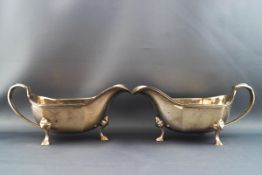 A pair of silver sauce boats, each standing on three shell feet, Sheffield 1934, 12.