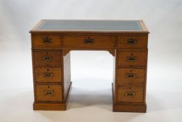 An Edwardian oak pedestal desk with three drawers below a green leather inset writing surface,