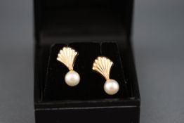 A pair of 9 carat gold and pearl stud earrings in the design of a shell.
