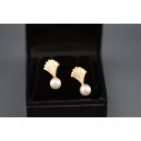 A pair of 9 carat gold and pearl stud earrings in the design of a shell.